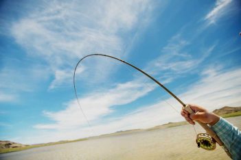 A person holding a fishing rod in the water.