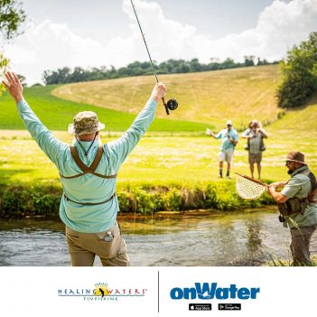A group of people fly fishing in a field.