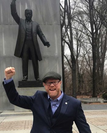 A man standing in front of a statue of lincoln.