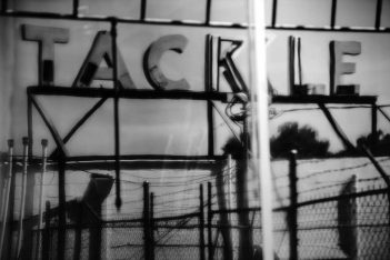 A black and white photo of a sign that says tackle.