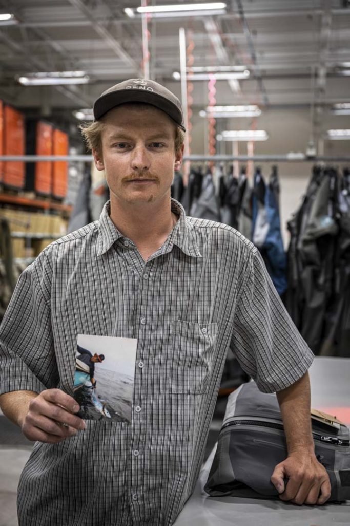 A man holding a photo in a warehouse.