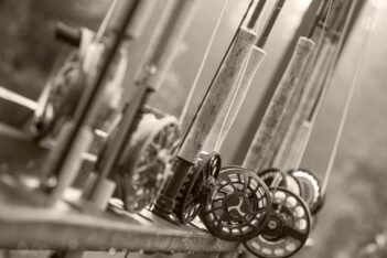 A black and white photo of fishing rods and reels.