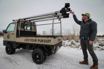 A man standing next to a truck with a camera on top.