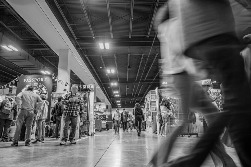 A black and white photo of people walking in a store.