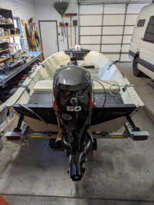 A boat in a garage with a motor attached to it.