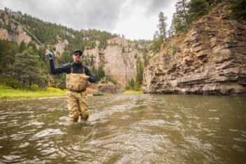 A man is fly fishing in a river.