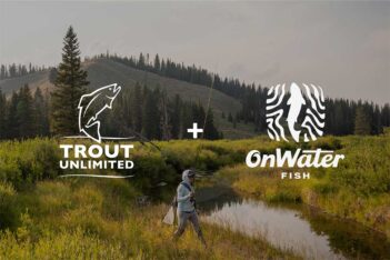 A person fly fishing in a serene river, surrounded by lush greenery, with logos of "trout unlimited" and "onwater fish" positioned on the right.
