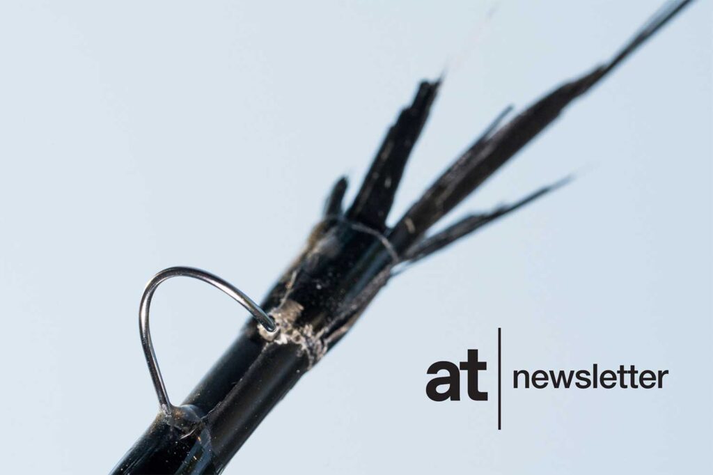 Close-up of a broken fishing rod with frayed fiberglass splinters, positioned next to the words "at newsletter" on a light background.