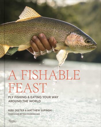 A person holds a trout above water. The book title reads "A Fishable Feast: Fly Fishing & Eating Your Way Around the World" by Kirk Deeter & Matthew Supinski.